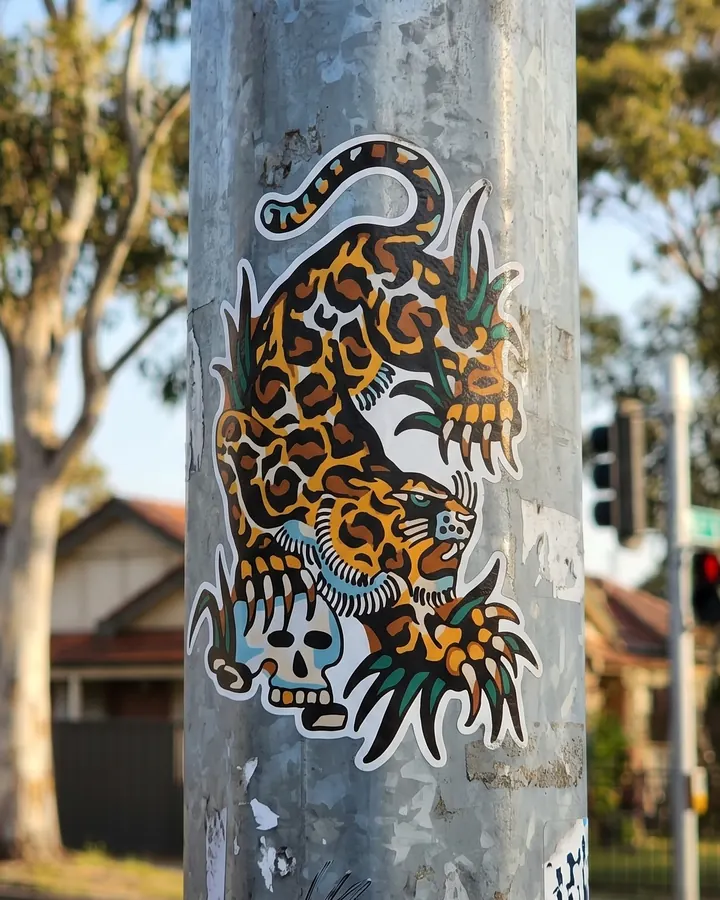 A leopard and skull sticker on a street pole